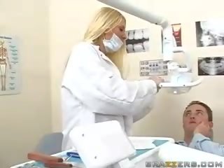 Superb teen busty blonde dentist shows her boobs to a patient