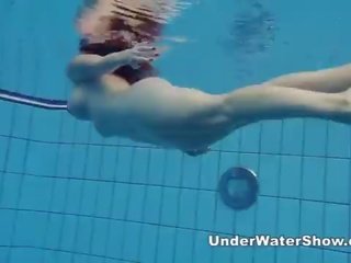 Redheaded feature swimming nude in the pool