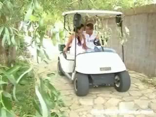 Ένα νέος κυρία και αυτήν νέος άνθρωπος είναι driving γύρω σε ένα γκολφ cart. ξαφνικά αυτοί στάση και ο stripling οδηγεί να αφή ο κορίτσι επάνω,